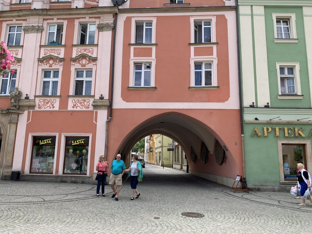 The market square in Boleslawiec, Poland, with pastel townhouses and an archway