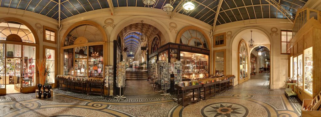 Inside the Galerie Vivienne, a glass-roofed 19th century covered passage in Paris, with shops and a mosaic floor