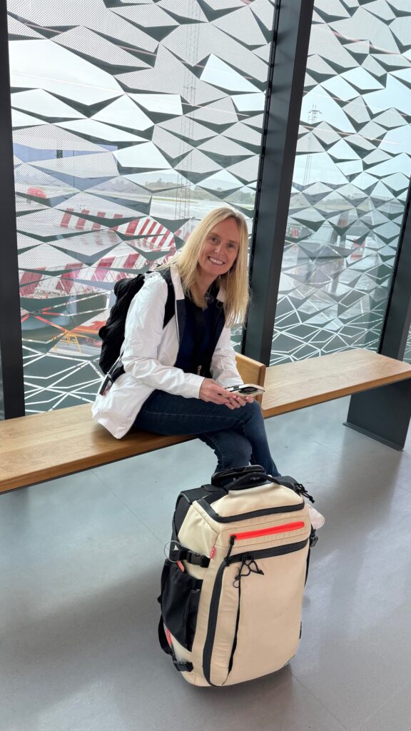 The Two Carry-On Bags I Travel With, and How to Pick Yours 1 Lisa with her cream Bagsmart Blast Pro 43L carry-on at the airport